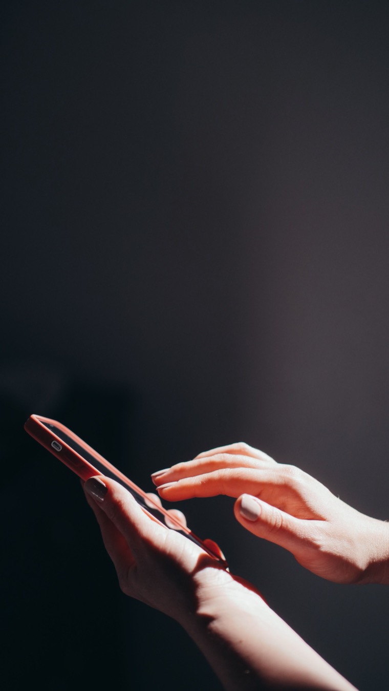 Hands typing a message on a phone